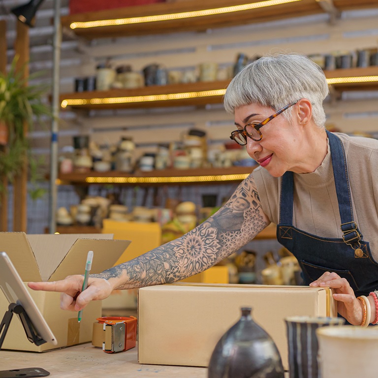 Lady in her shop with her fingers at the till machine