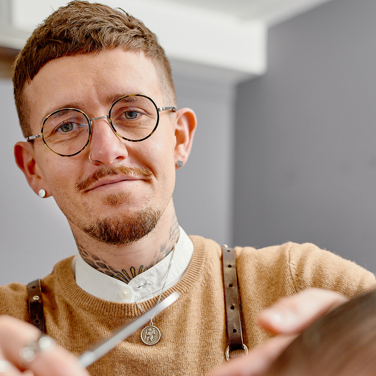 self employed barber man in a shop holding a scissors self employed barber man in a shop holding a scissors